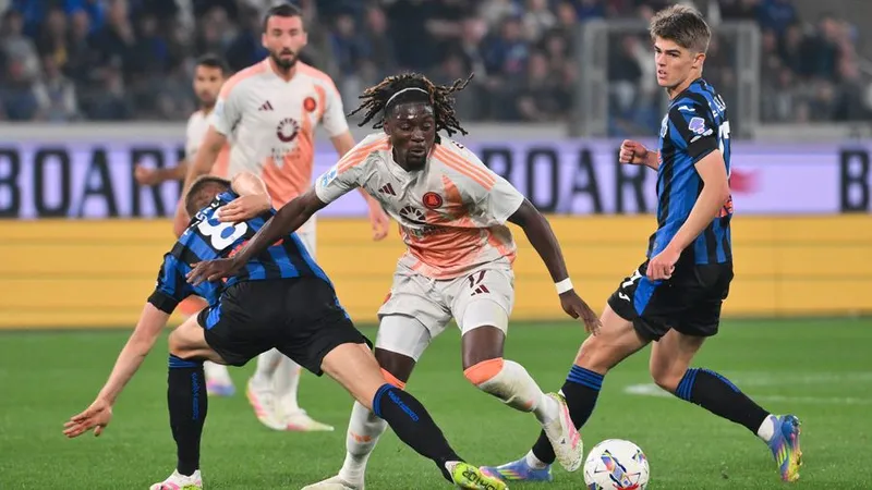 Cầu thủ AS Roma và Atalanta tranh chấp quả bóng trên sân cỏ Cầu thủ AS Roma và Atalanta tranh chấp quả bóng trên sân cỏ